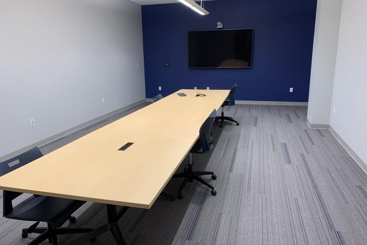 Lupton Hall's first floor conference room, containing a conference table, chairs, and monitor